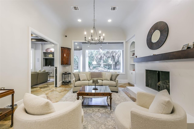 living room with built in features, lofted ceiling, and a notable chandelier