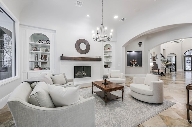 living room featuring built in features and an inviting chandelier