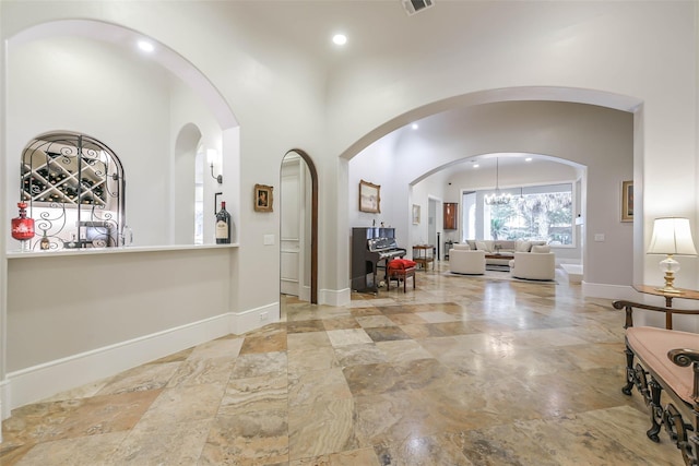 interior space with a towering ceiling and a chandelier