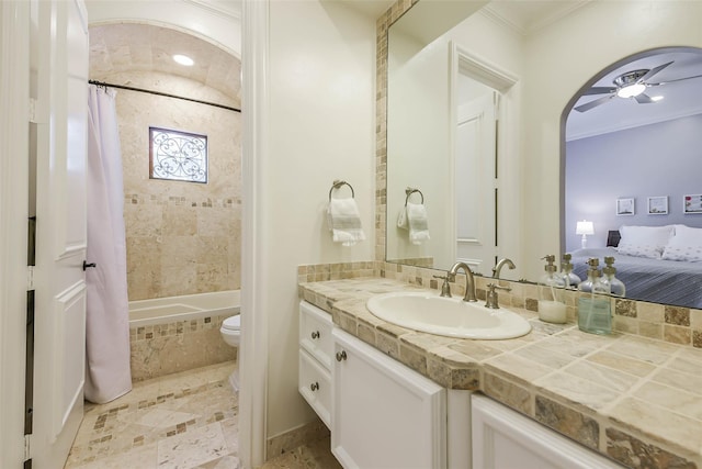 full bathroom featuring vanity, ceiling fan, toilet, shower / bathtub combination with curtain, and ornamental molding