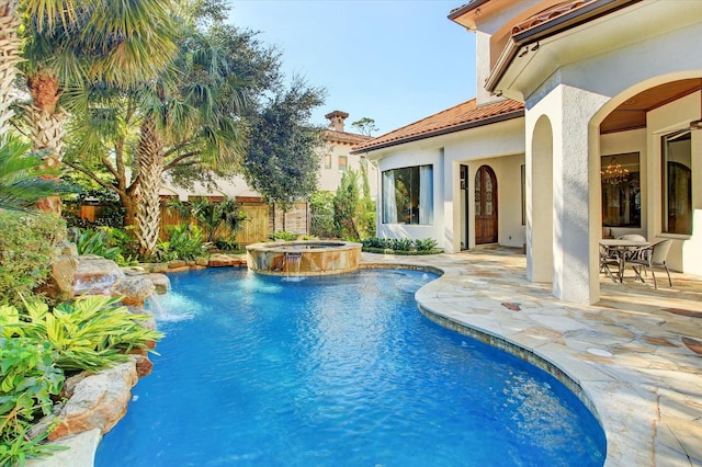 view of pool with an in ground hot tub, pool water feature, and a patio area