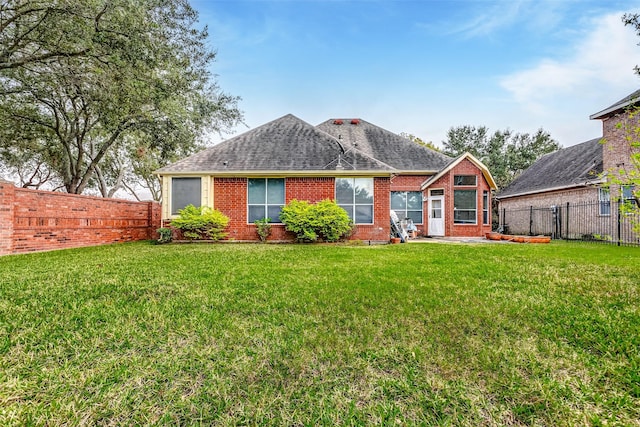 rear view of property with a yard