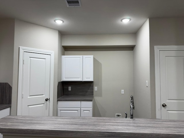 kitchen with decorative backsplash and white cabinetry