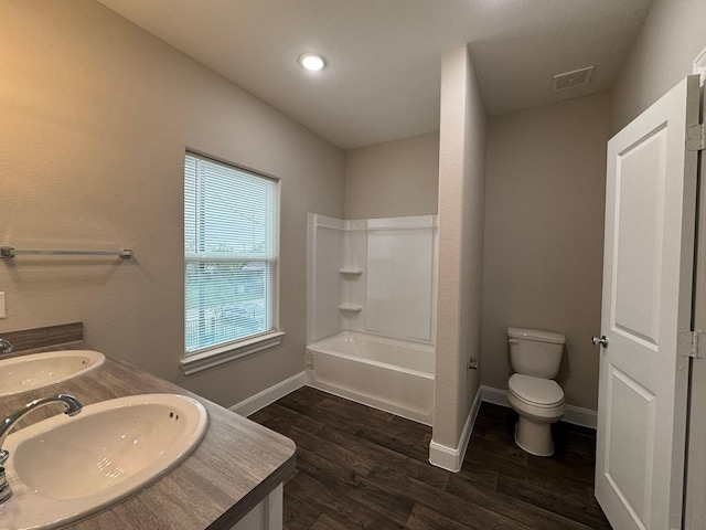 full bathroom with hardwood / wood-style floors, vanity, shower / bath combination, and toilet