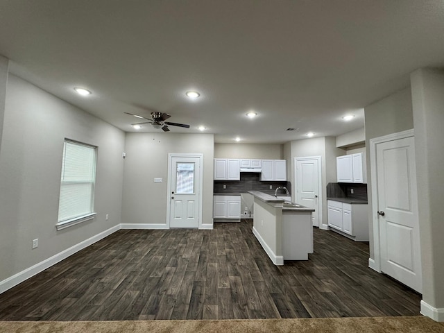 kitchen featuring white cabinetry, ceiling fan, sink, dark hardwood / wood-style flooring, and a kitchen island with sink