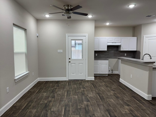 kitchen featuring white cabinets, sink, ceiling fan, decorative backsplash, and dark hardwood / wood-style flooring