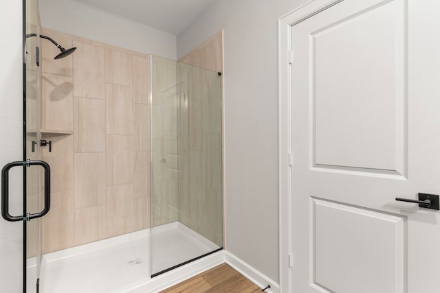 bathroom featuring wood-type flooring and a shower with door