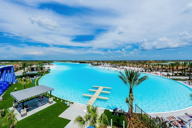 view of swimming pool with a lawn and a water view