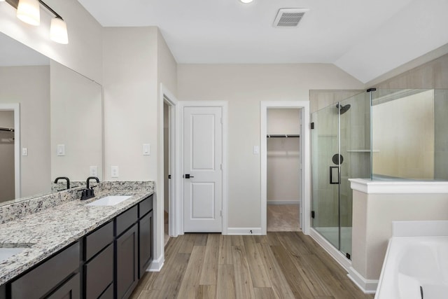 bathroom featuring shower with separate bathtub, vanity, hardwood / wood-style flooring, and vaulted ceiling