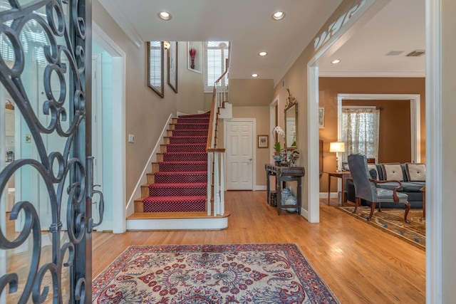 foyer with light wood-type flooring and ornamental molding