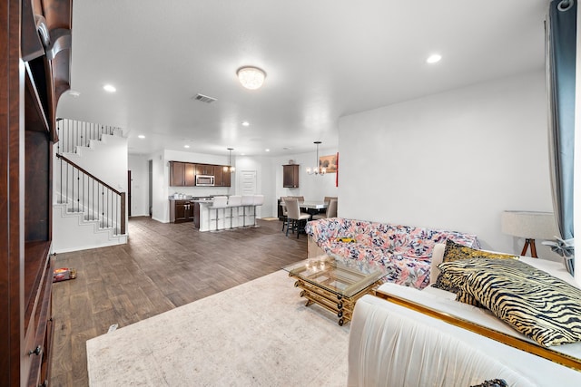 living room with a notable chandelier and dark wood-type flooring