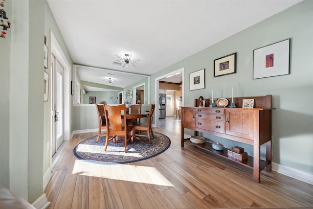 dining area with baseboards and wood finished floors