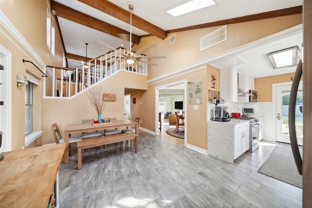 dining room featuring high vaulted ceiling, visible vents, baseboards, stairway, and beamed ceiling