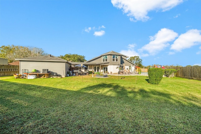 rear view of property with a yard, a patio area, and a fenced backyard