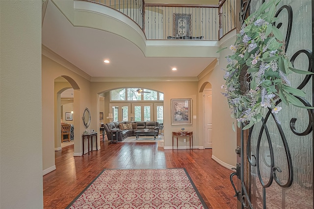 entrance foyer featuring crown molding, hardwood / wood-style floors, a high ceiling, and french doors