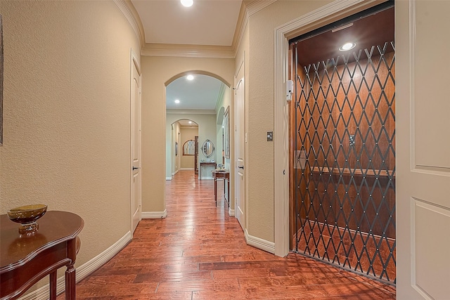 hall featuring elevator, ornamental molding, and hardwood / wood-style flooring