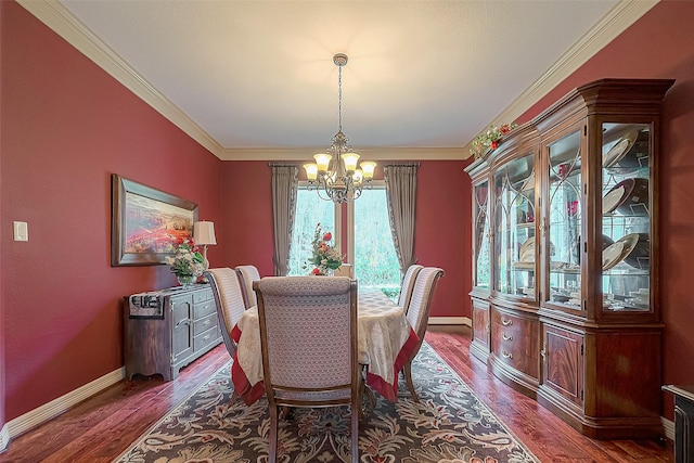 dining space with dark hardwood / wood-style flooring, a chandelier, and ornamental molding