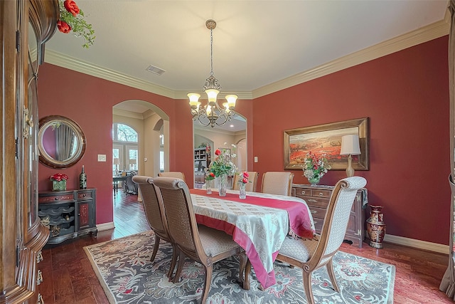 dining room featuring dark wood-type flooring, a notable chandelier, and ornamental molding