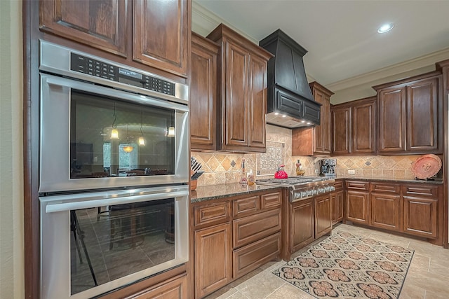 kitchen featuring stainless steel appliances, tasteful backsplash, dark stone counters, custom exhaust hood, and ornamental molding