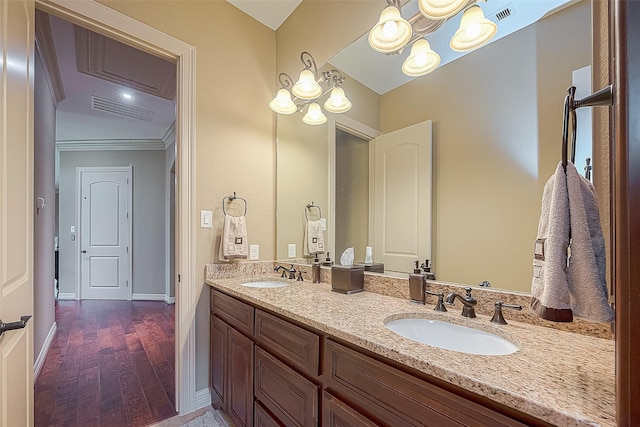 bathroom with ornamental molding, vanity, wood-type flooring, a notable chandelier, and lofted ceiling