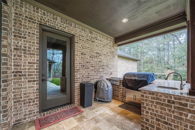 view of patio / terrace with a wet bar, grilling area, and exterior kitchen