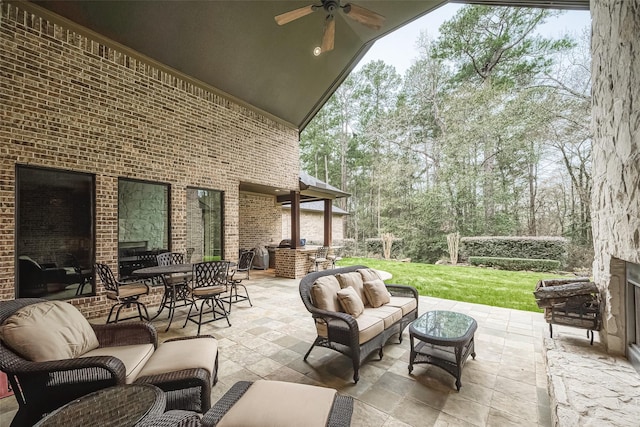 view of patio with an outdoor living space with a fireplace and ceiling fan