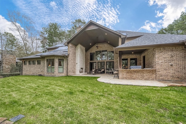 back of property with a yard and a patio