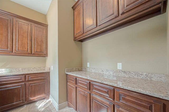 kitchen with light stone counters and light tile patterned floors