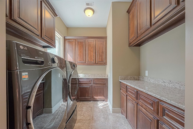 clothes washing area featuring light tile patterned floors, cabinets, and independent washer and dryer