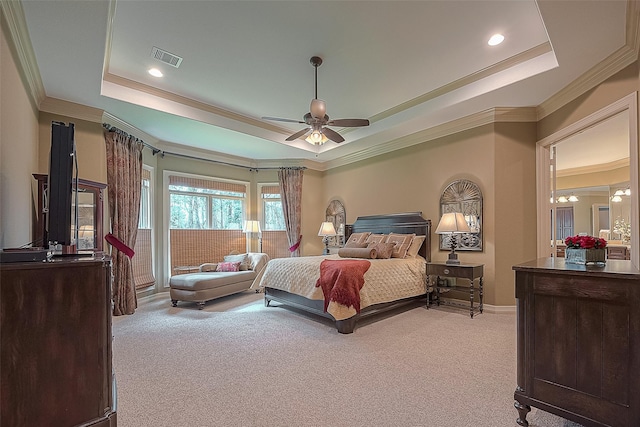 carpeted bedroom featuring ceiling fan with notable chandelier, a tray ceiling, and crown molding