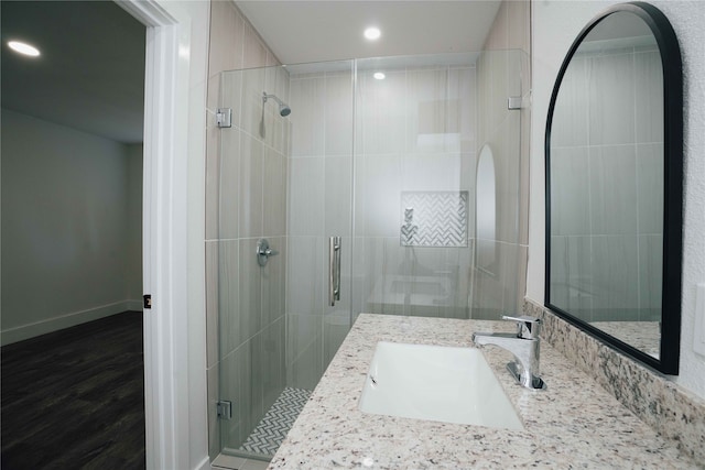 bathroom with hardwood / wood-style floors, vanity, and walk in shower