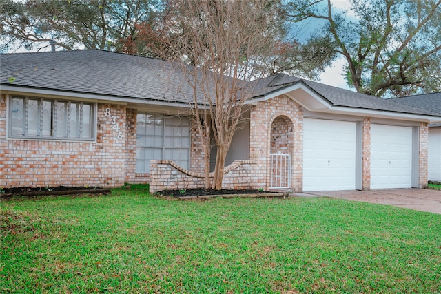 ranch-style home featuring a garage and a front lawn