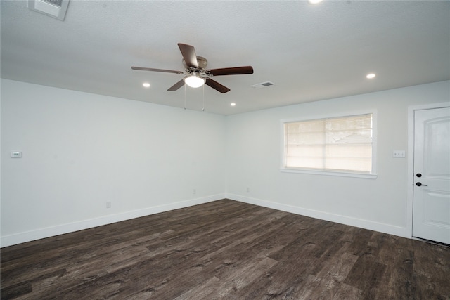 unfurnished room with ceiling fan, dark wood-type flooring, and a textured ceiling