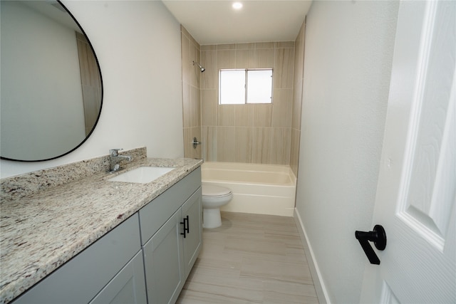 full bathroom featuring vanity, tiled shower / bath combo, and toilet