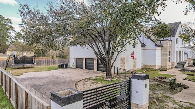 view of side of property with a garage and a trampoline