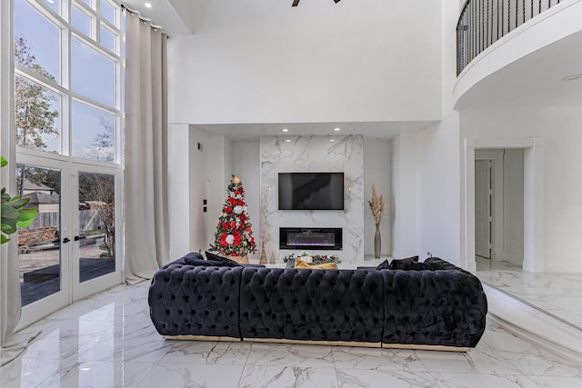 living room featuring a high ceiling, french doors, and a premium fireplace