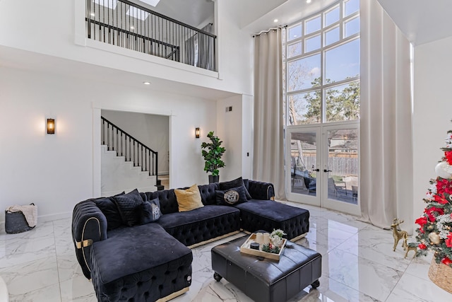 living room with a towering ceiling and french doors