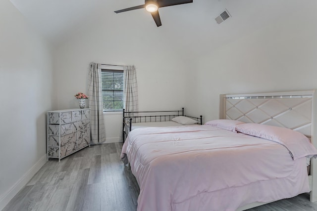 bedroom featuring ceiling fan, hardwood / wood-style floors, and lofted ceiling