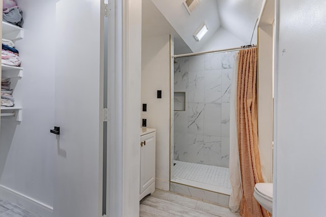 bathroom with toilet, vaulted ceiling, and walk in shower