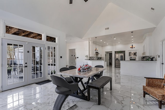 dining area featuring french doors and high vaulted ceiling