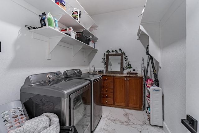 washroom with washer and clothes dryer and cabinets