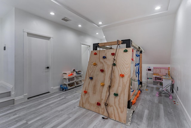 game room with light hardwood / wood-style floors and vaulted ceiling