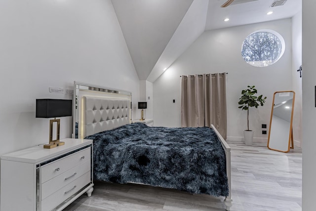 bedroom with high vaulted ceiling and light hardwood / wood-style floors