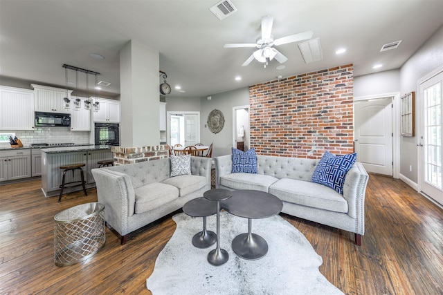 living room featuring ceiling fan and dark wood-type flooring