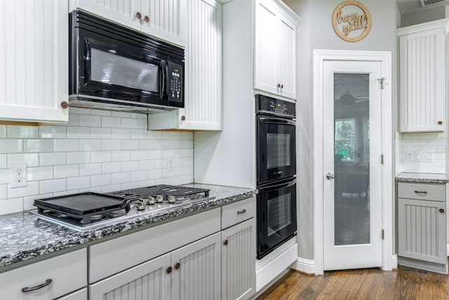 kitchen with white cabinetry, dark hardwood / wood-style flooring, black appliances, and stone countertops