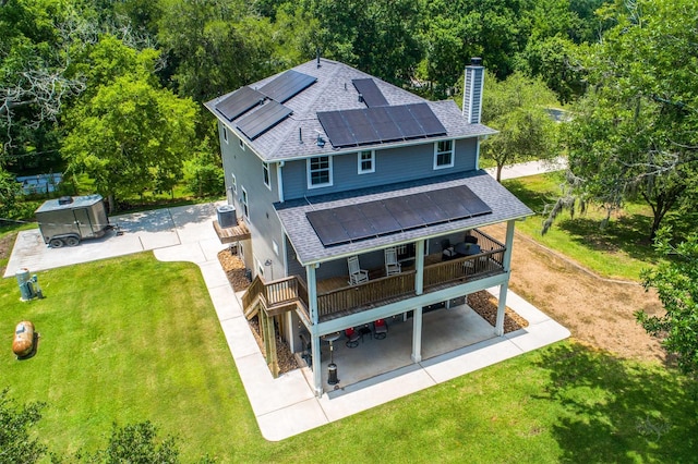 back of house featuring a lawn, solar panels, central AC, a patio area, and a deck