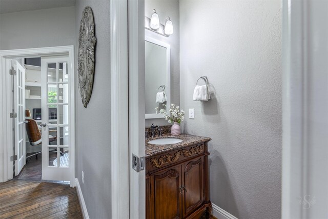 bathroom with french doors, vanity, and hardwood / wood-style floors