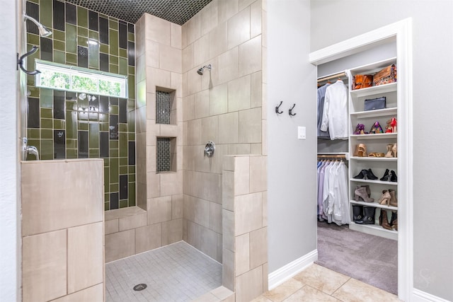 bathroom featuring tiled shower and tile patterned flooring