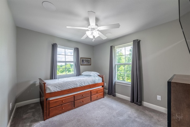 bedroom with light colored carpet, multiple windows, and ceiling fan