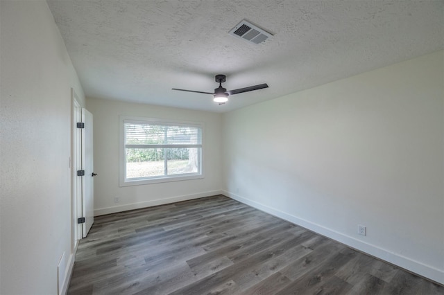 empty room featuring ceiling fan, dark hardwood / wood-style flooring, and a textured ceiling